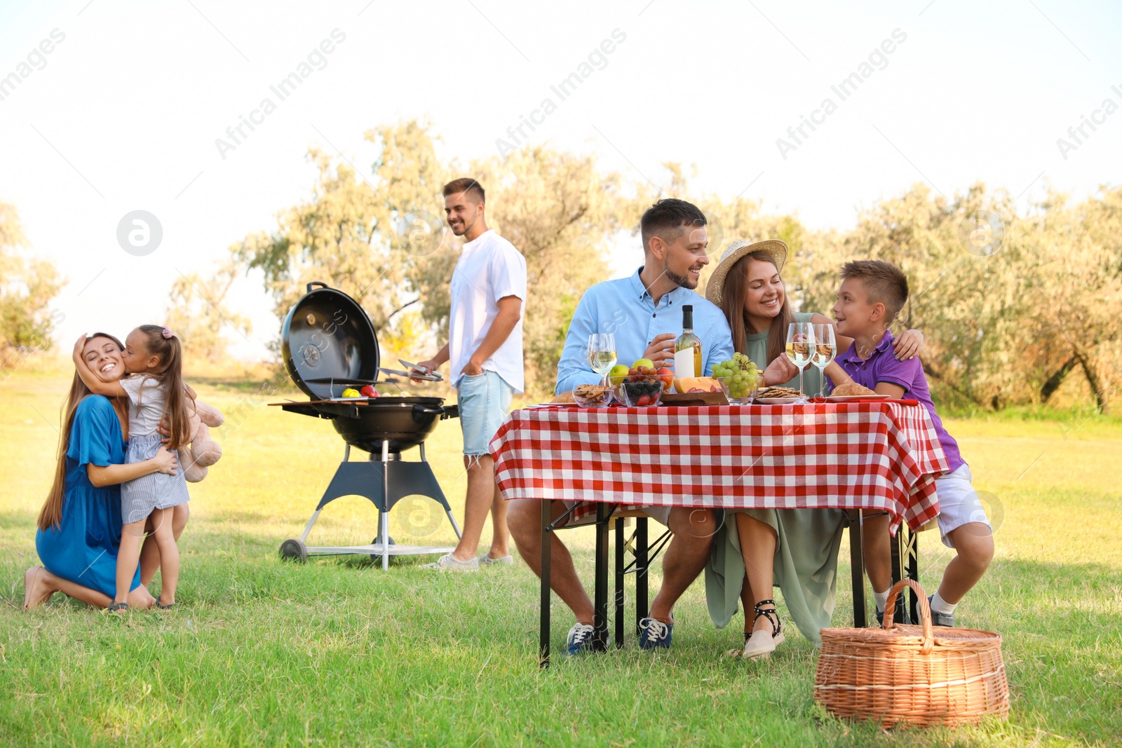 Photo of Happy families with little children having picnic in park