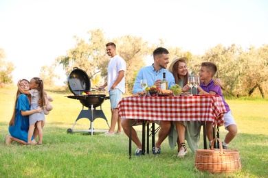 Photo of Happy families with little children having picnic in park