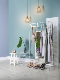Photo of Stylish dressing room interior with clothes on rack