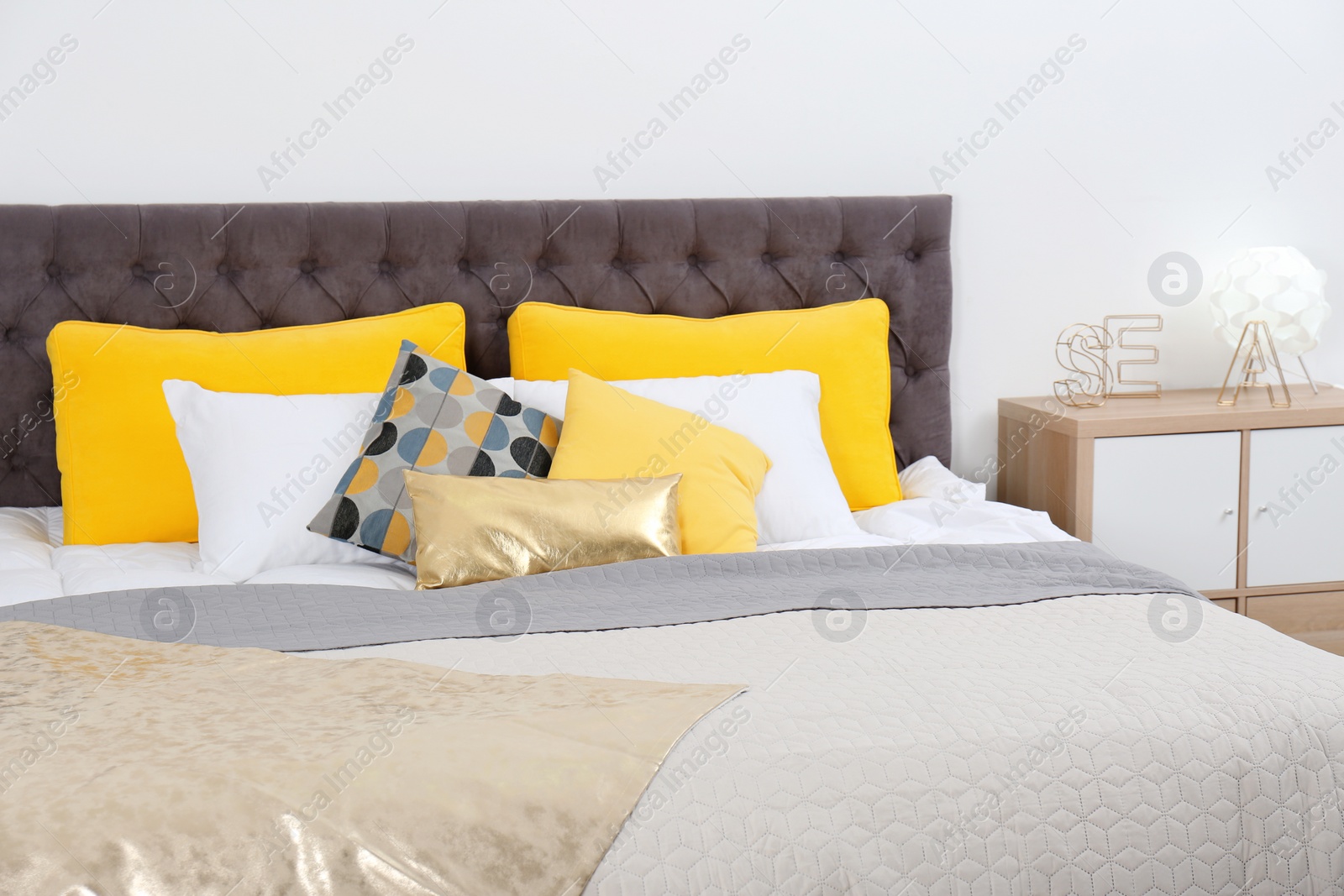 Photo of Big bed with soft pillows in stylish room interior