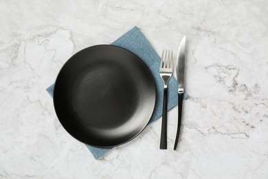 Stylish setting with elegant cutlery on white marble table, top view