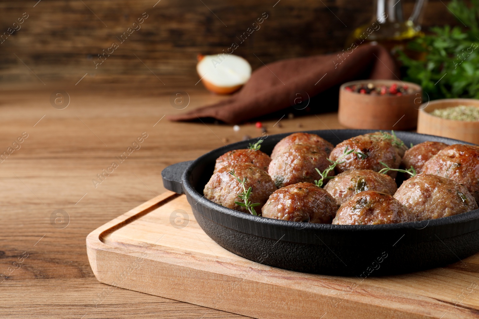 Photo of Tasty cooked meatballs served on wooden table. Space for text