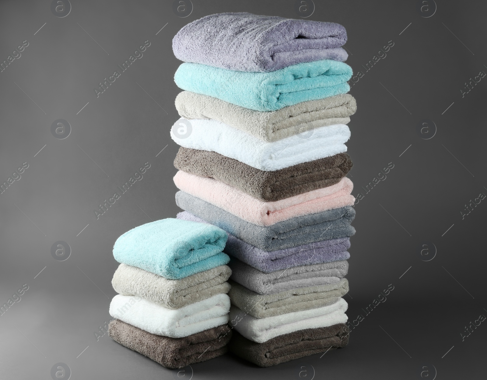 Photo of Different fresh soft terry towels on grey background