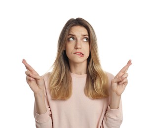 Photo of Woman with crossed fingers on white background. Superstition concept