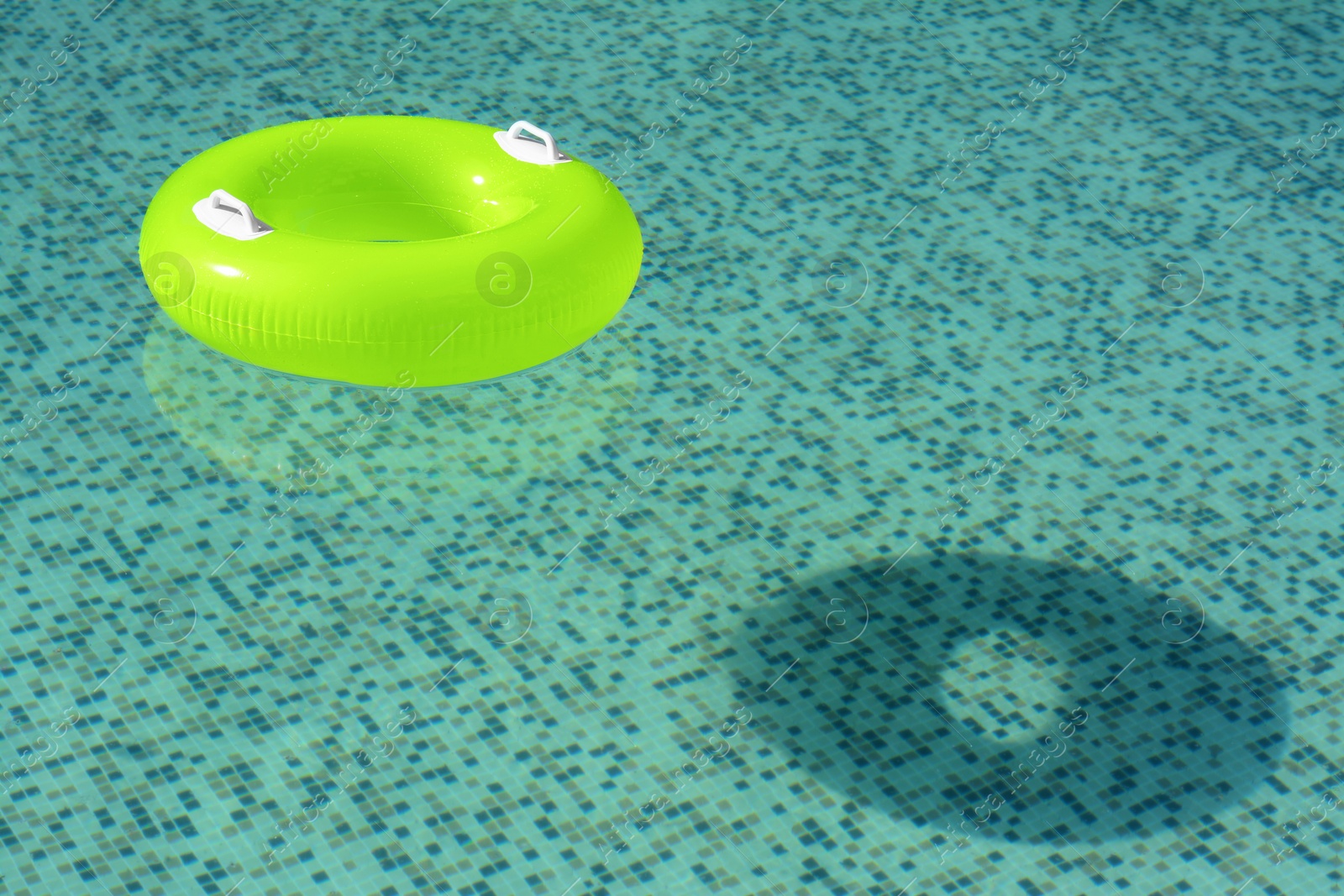 Photo of Light green inflatable ring floating in swimming pool. space for text