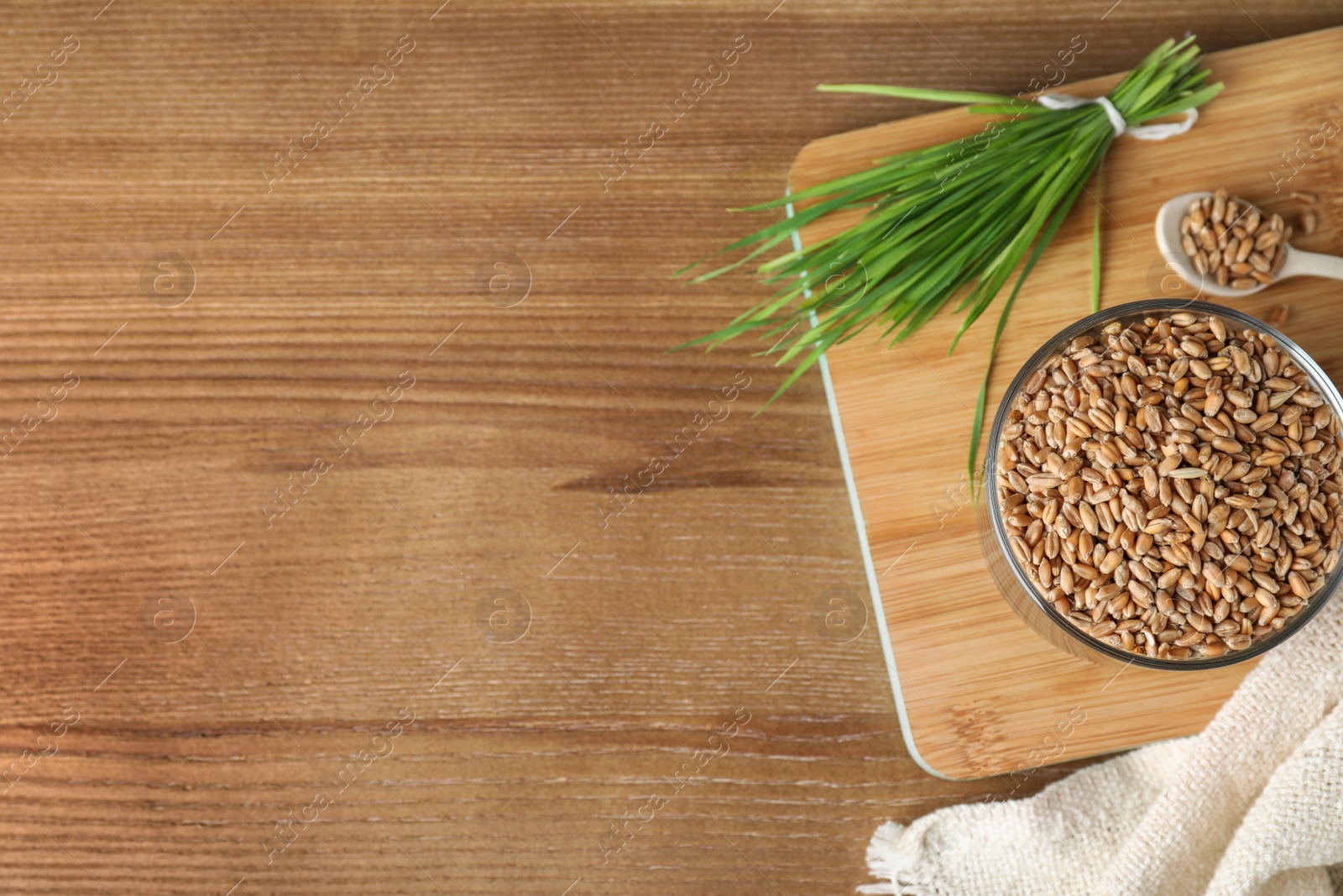 Photo of Bowl with seeds and wheat grass on wooden background, flat lay. Space for text