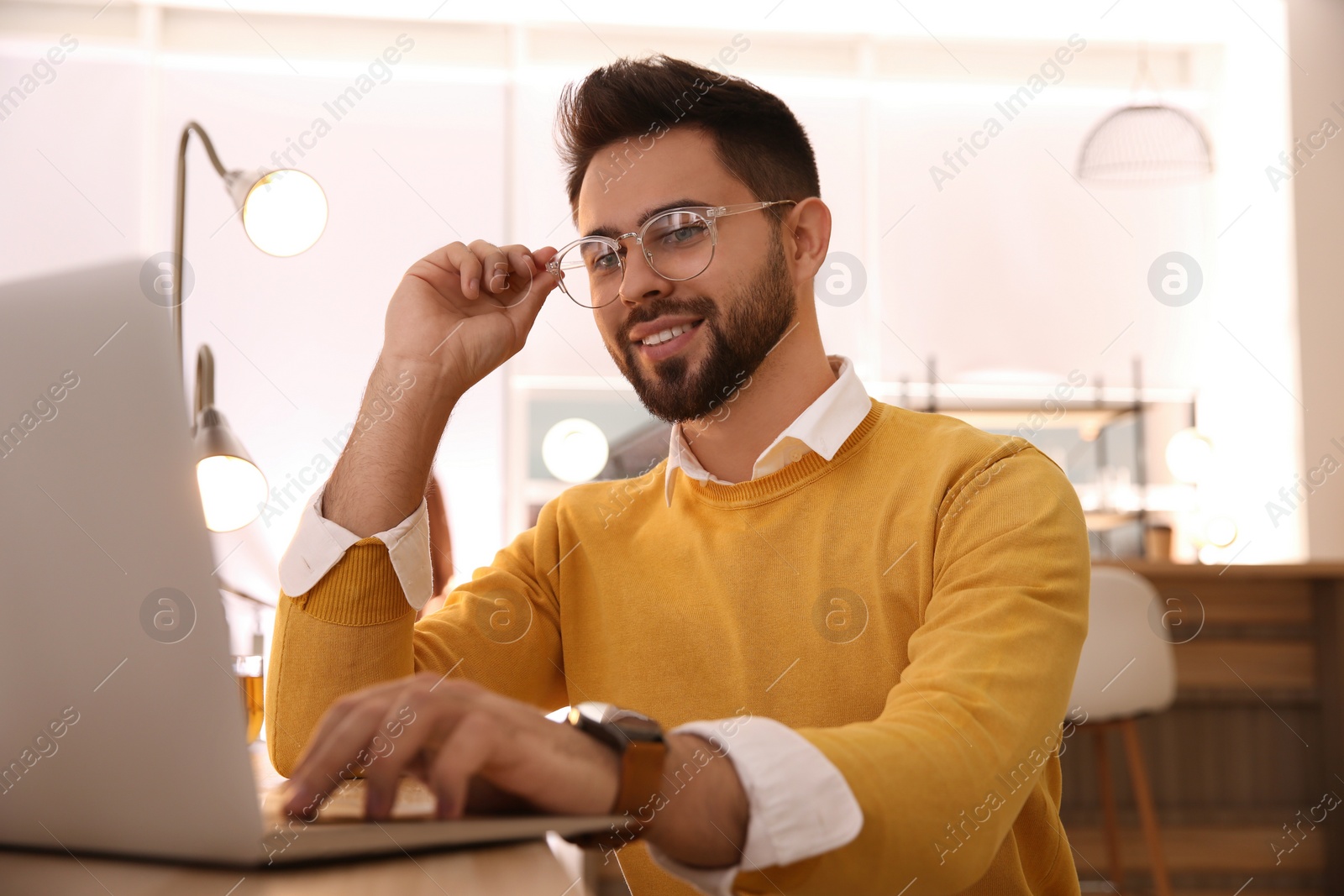 Photo of Man working with laptop at table in cafe