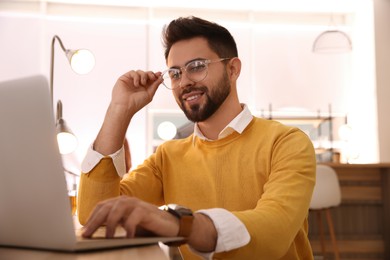 Man working with laptop at table in cafe