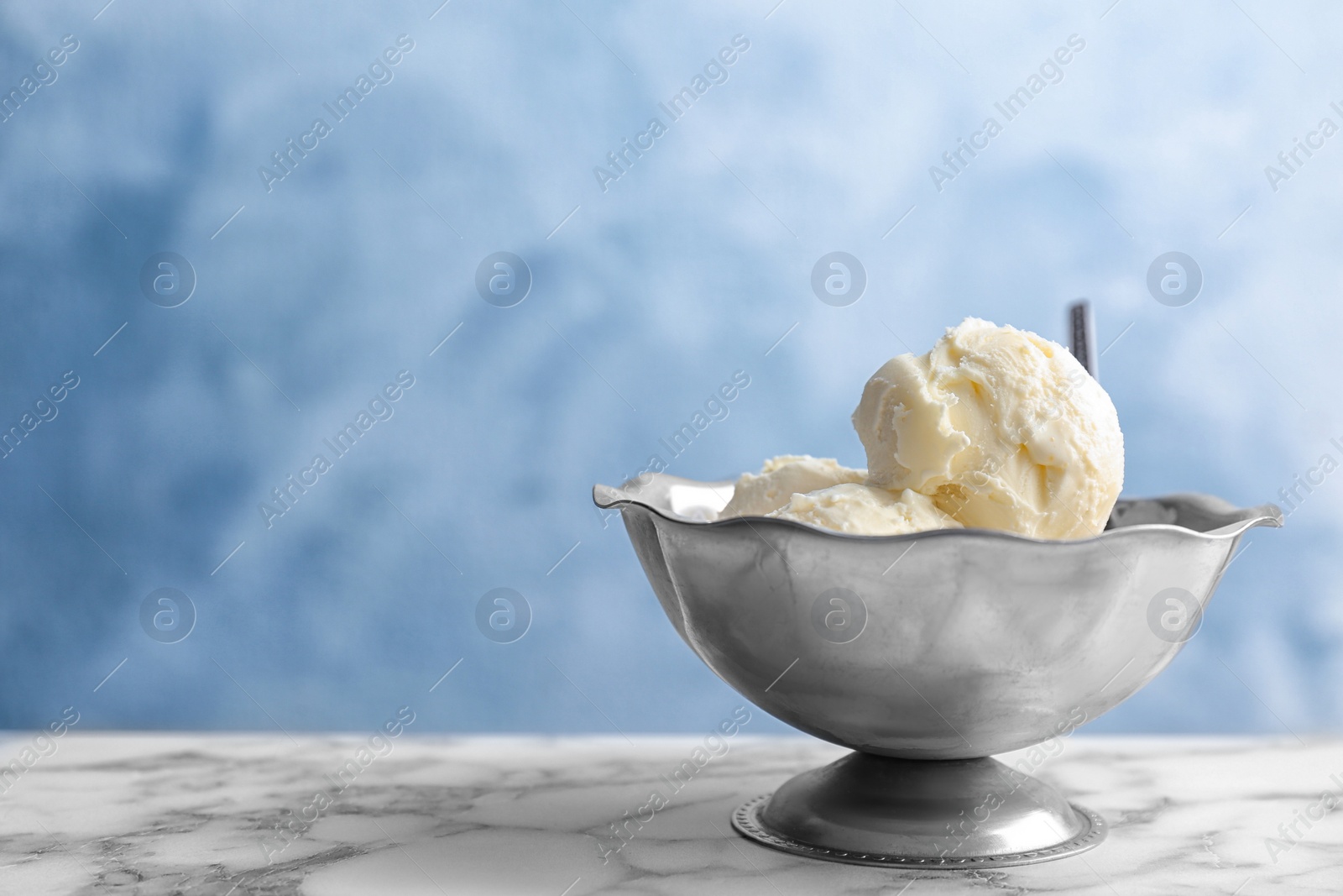 Photo of Bowl with tasty vanilla ice cream on table