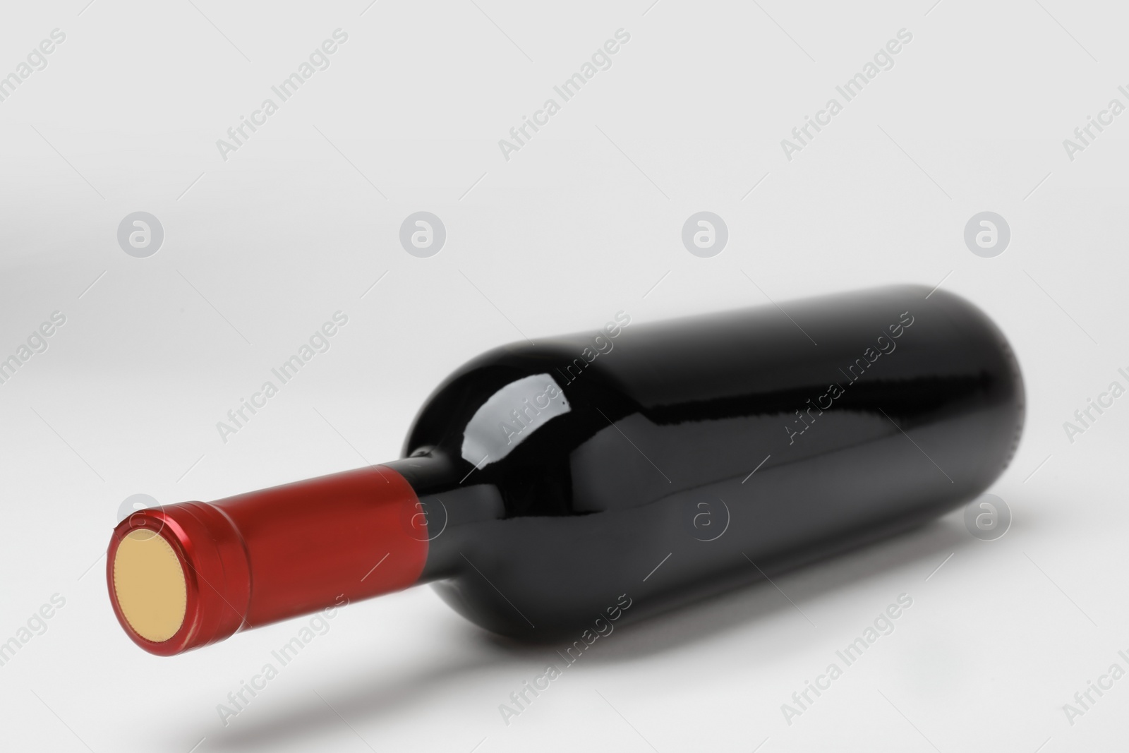 Photo of Bottle of expensive red wine on light background