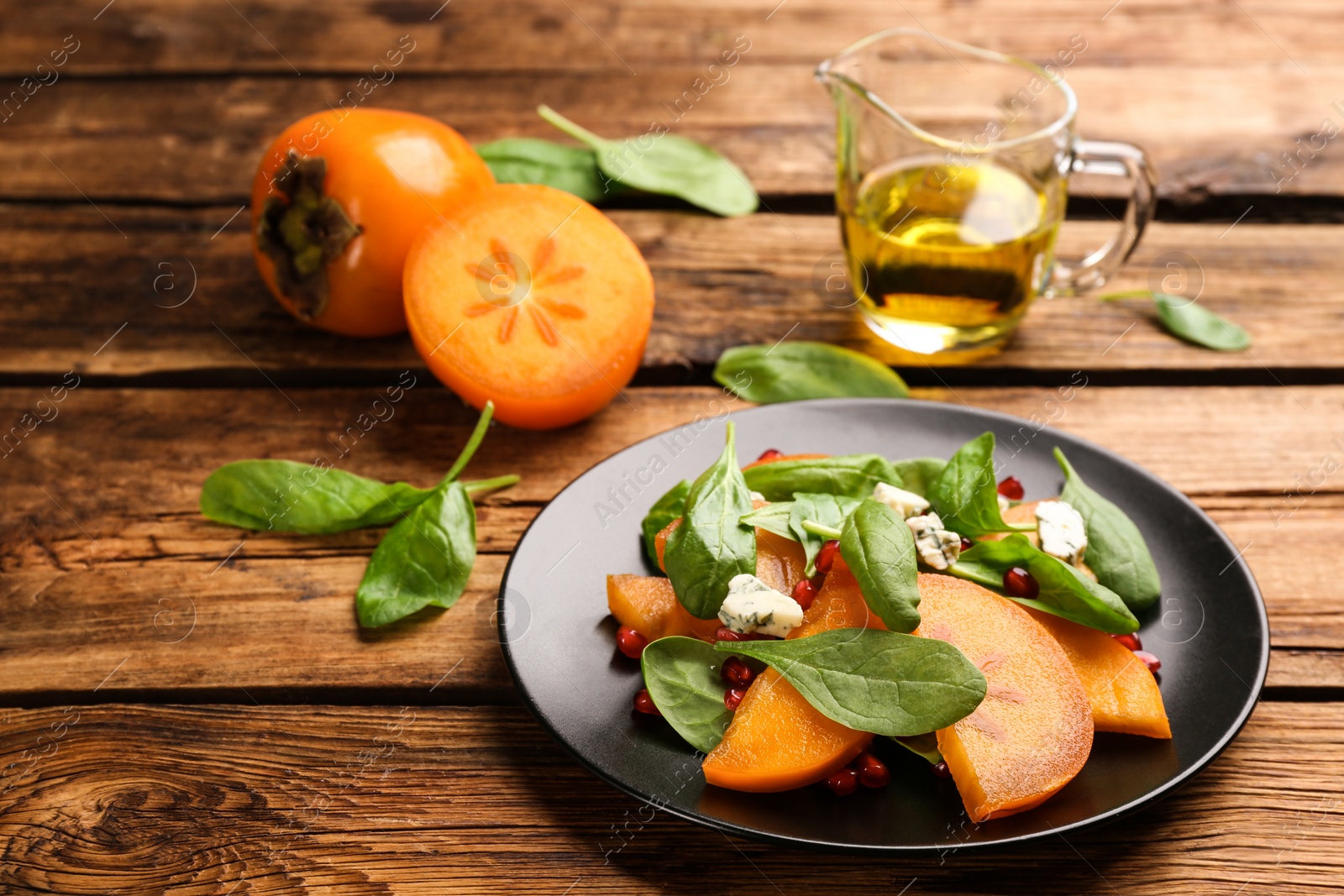 Photo of Delicious persimmon salad served on wooden table