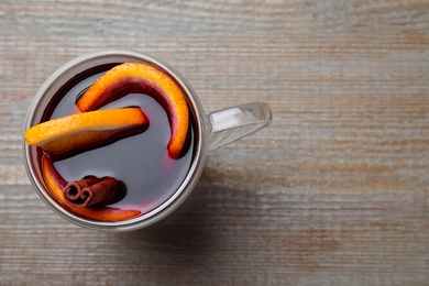 Aromatic mulled wine on wooden table, top view. Space for text