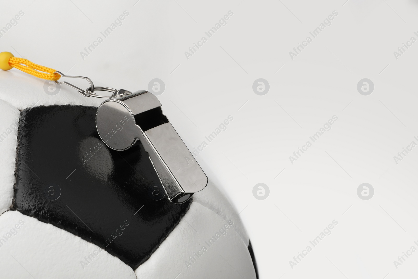 Photo of Football referee equipment. Soccer ball and whistle on white background