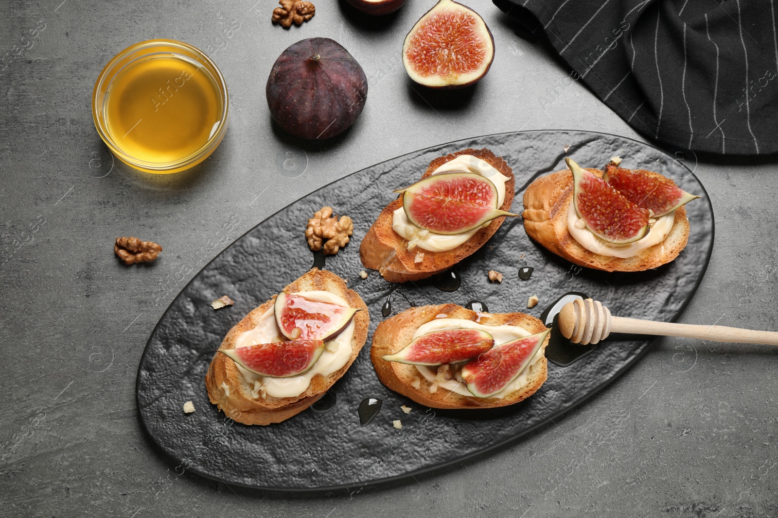 Photo of Bruschettas with ripe figs and cream cheese served on grey table, top view