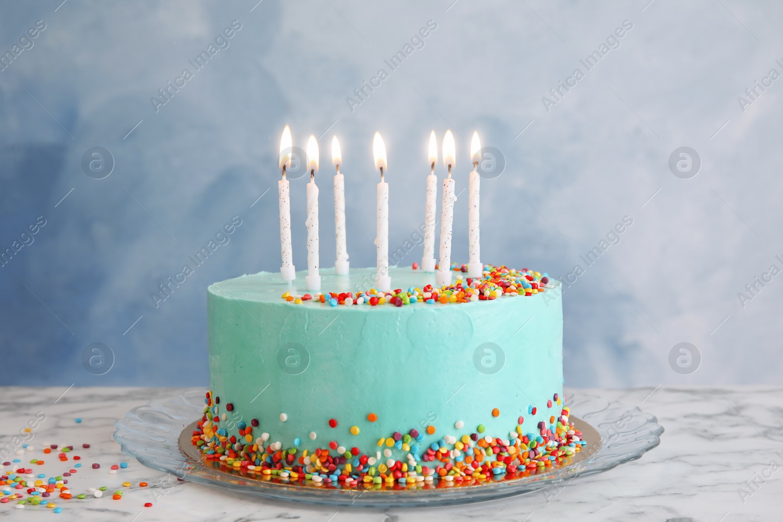 Photo of Fresh delicious birthday cake with candles on table against color background