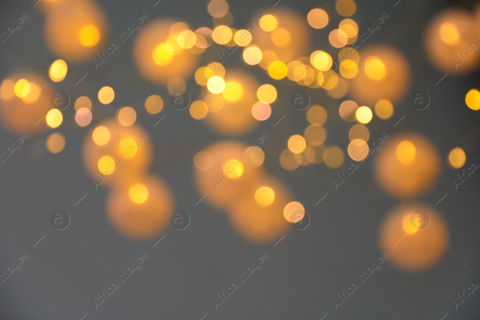 Photo of Blurred view of gold lights on dark background. Bokeh effect