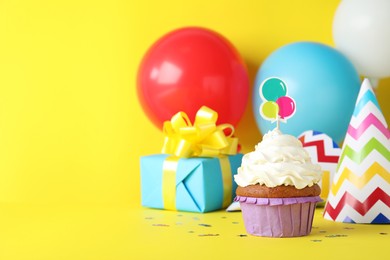 Photo of Delicious birthday cupcake on yellow background, space for text
