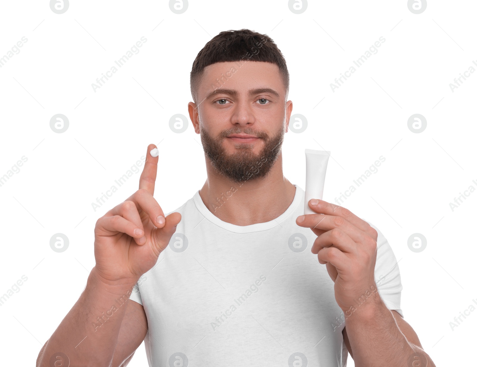 Photo of Handsome man with tube of body cream on white background