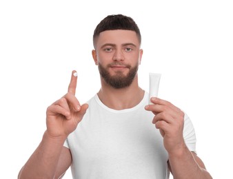 Handsome man with tube of body cream on white background