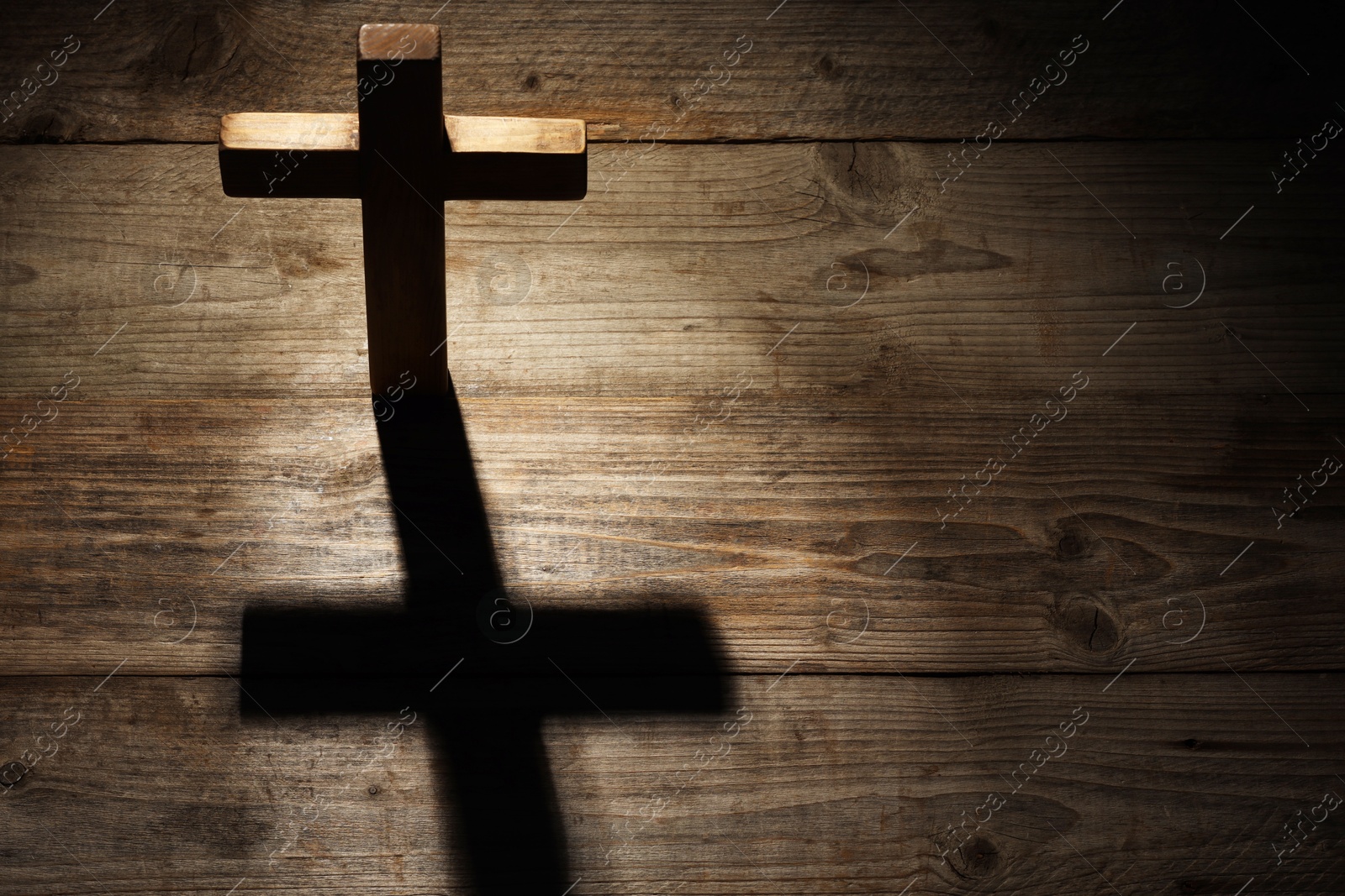 Photo of Cross on wooden background, above view with space for text. Religion of Christianity