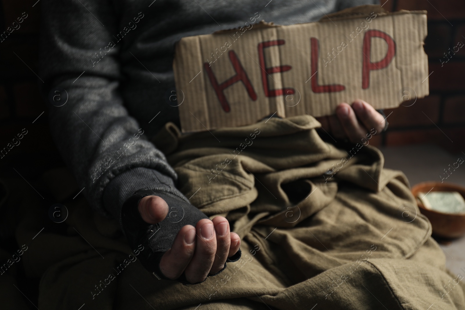 Photo of Poor homeless man with help sign begging for money, closeup. Charity and donation