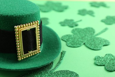 St. Patrick's day. Leprechaun hat and decorative clover leaves on green background