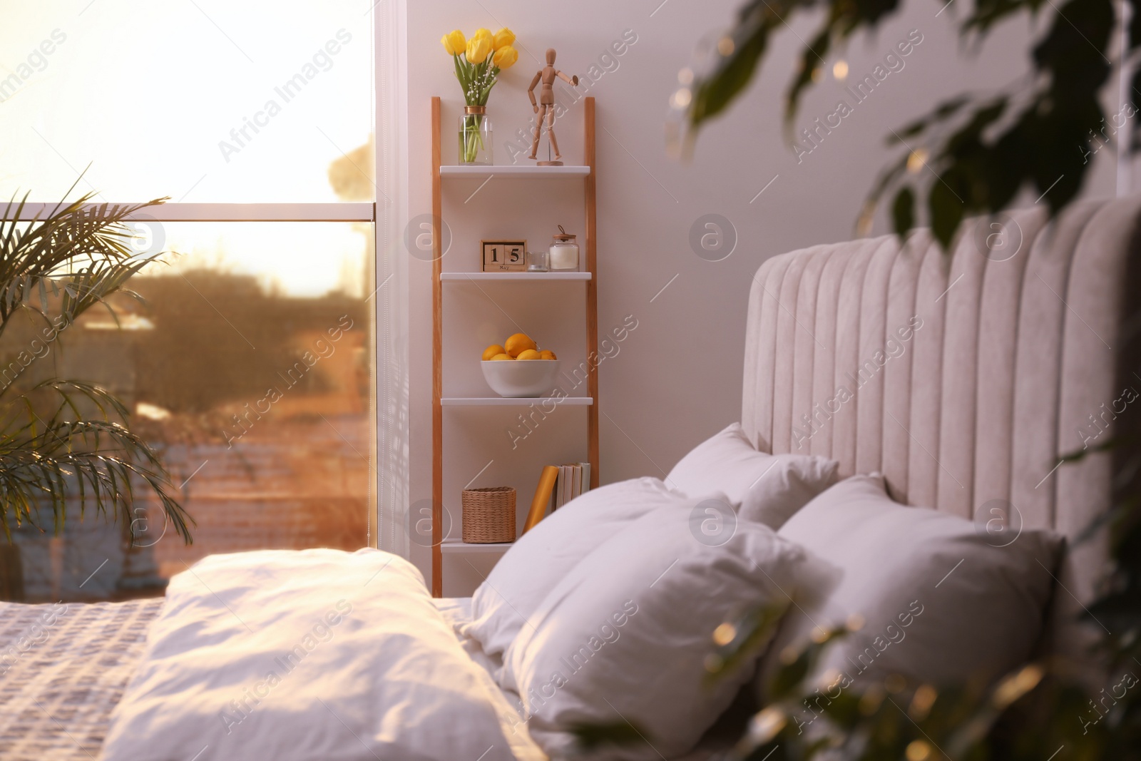 Photo of Stylish bedroom interior with wooden ladder near white wall