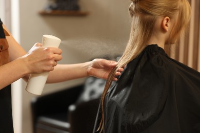 Photo of Professional hairdresser working with girl in beauty salon, closeup