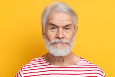 Senior man with mustache on orange background