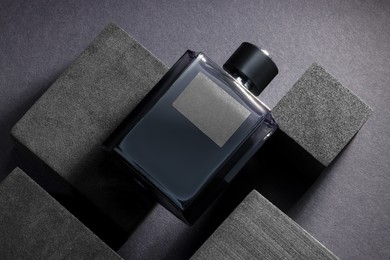 Stylish presentation of luxury men`s perfume in bottle on black background, top view