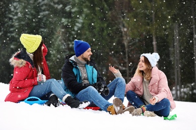 People with plastic sleds outdoors. Winter vacation