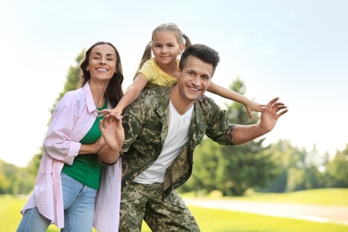 Photo of Man in military uniform and his family at sunny park