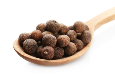 Photo of Wooden spoon with allspice pepper grains on white background