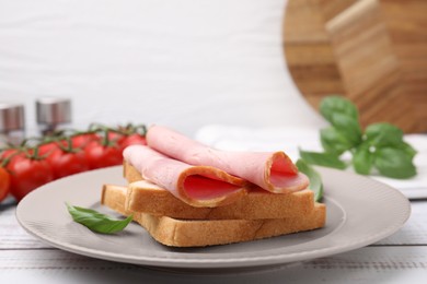 Photo of Delicious sandwich with ham on white wooden table, closeup