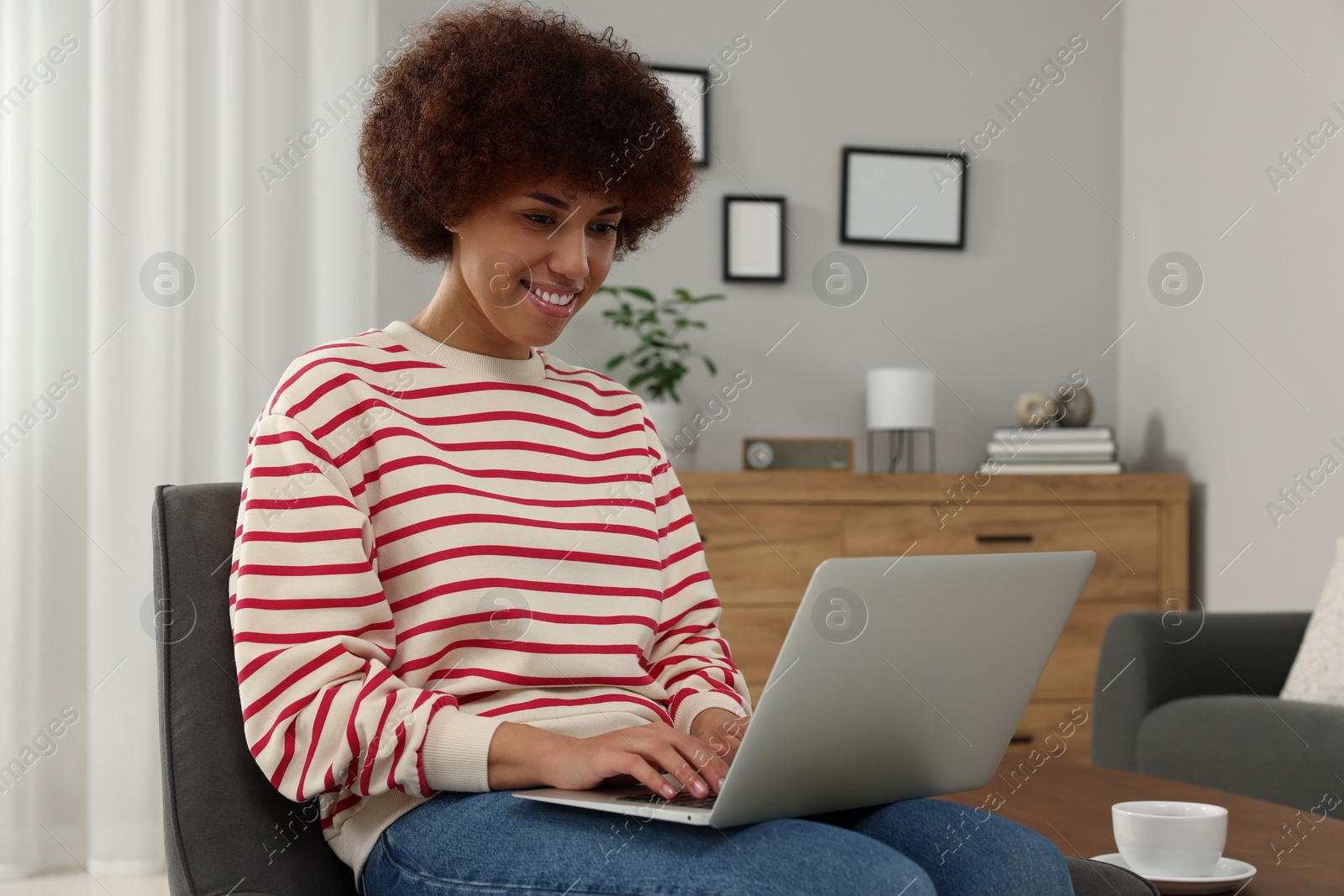 Photo of Beautiful young woman using laptop in room