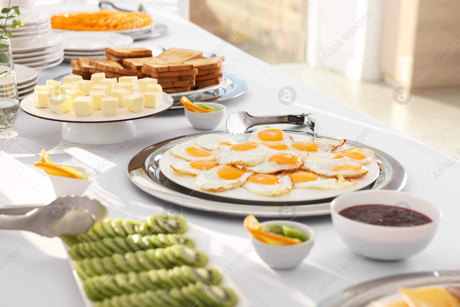 Photo of Different meals for breakfast on white table indoors. Buffet service