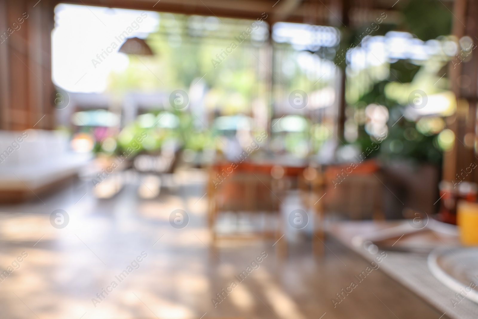 Photo of Blurred view of comfortable cafeteria with furniture