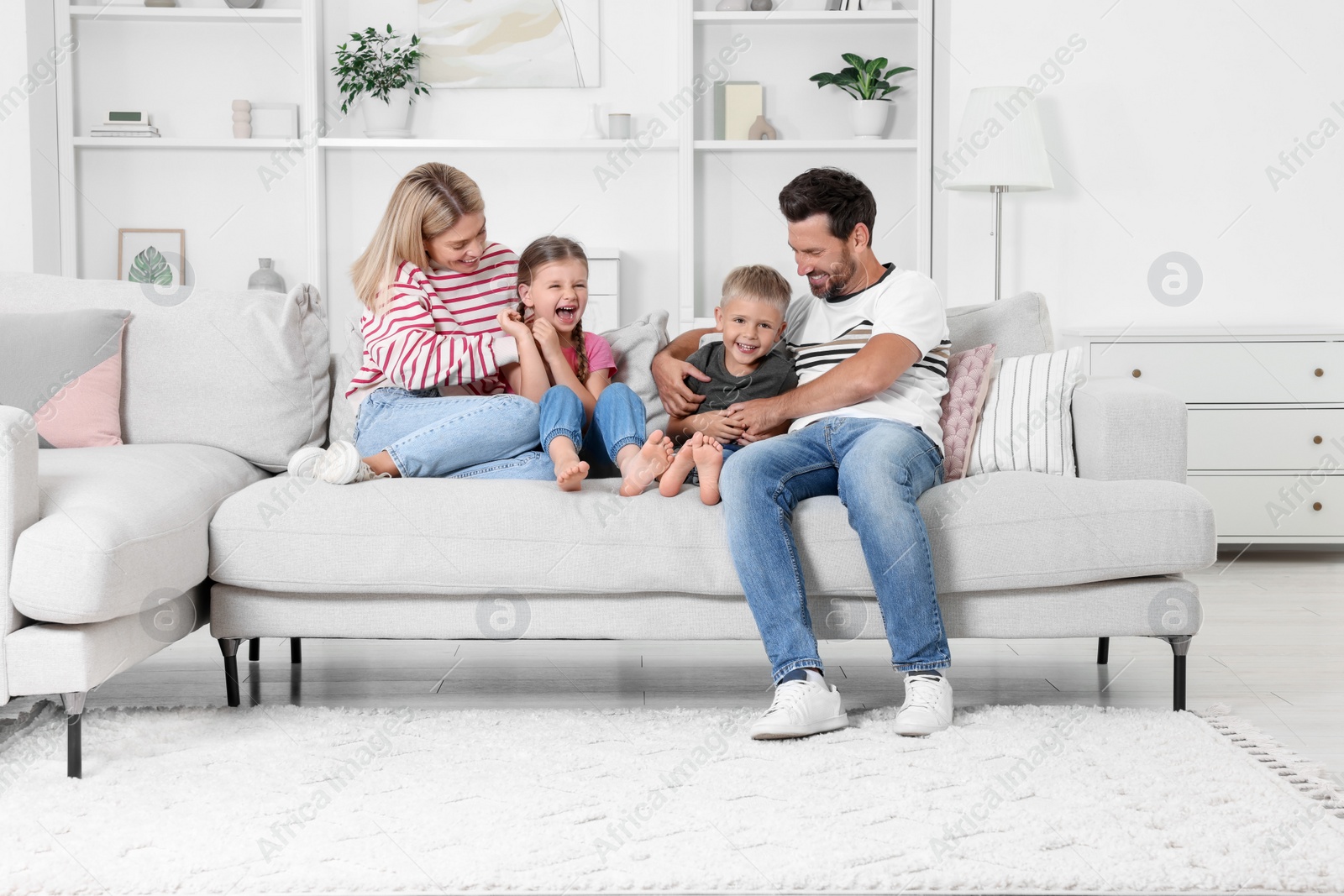 Photo of Happy family having fun together on sofa at home