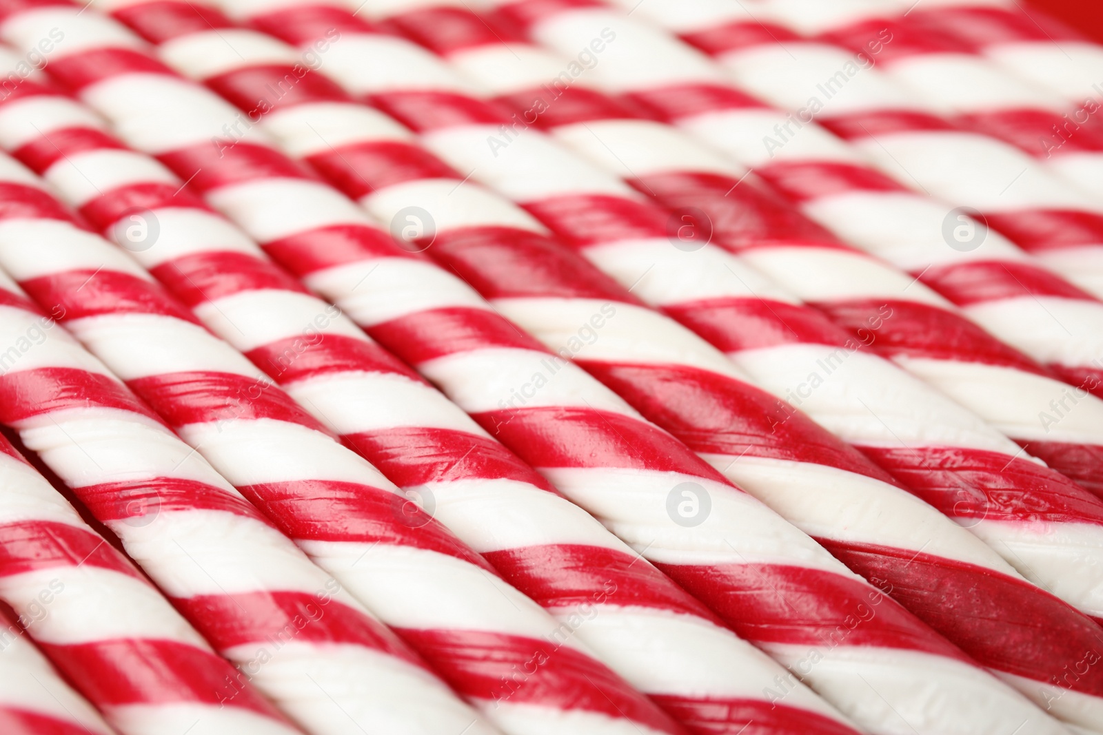 Photo of Sweet candy canes as background, closeup view