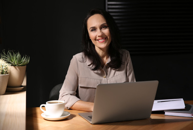 Beautiful mature woman working with laptop at home