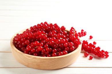 Photo of Delicious red currants on white wooden table