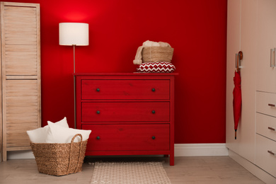 Photo of Modern room interior with red chest of drawers