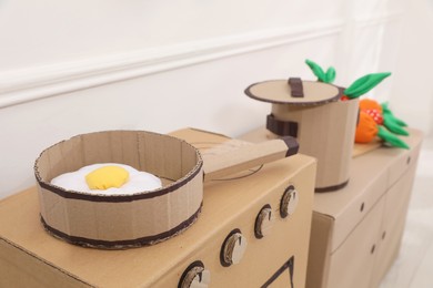Toy cardboard kitchen with frying pan indoors