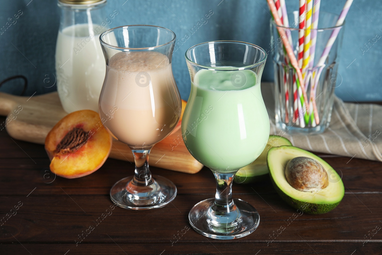 Photo of Glasses with delicious milk shakes and ingredients on table