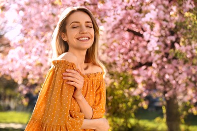 Young woman wearing stylish outfit in park on spring day. Fashionable look