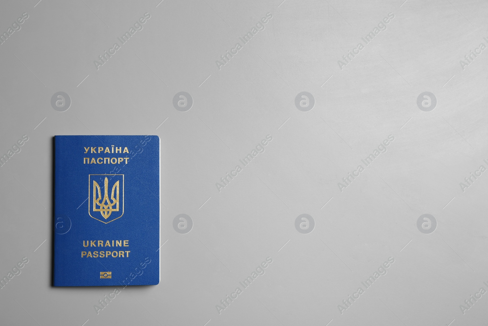 Photo of Ukrainian travel passport on grey background, top view with space for text. International relationships