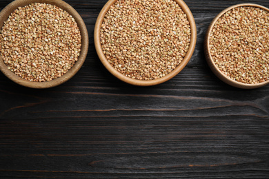 Photo of Flat lay composition with green buckwheat on black wooden table. Space for text