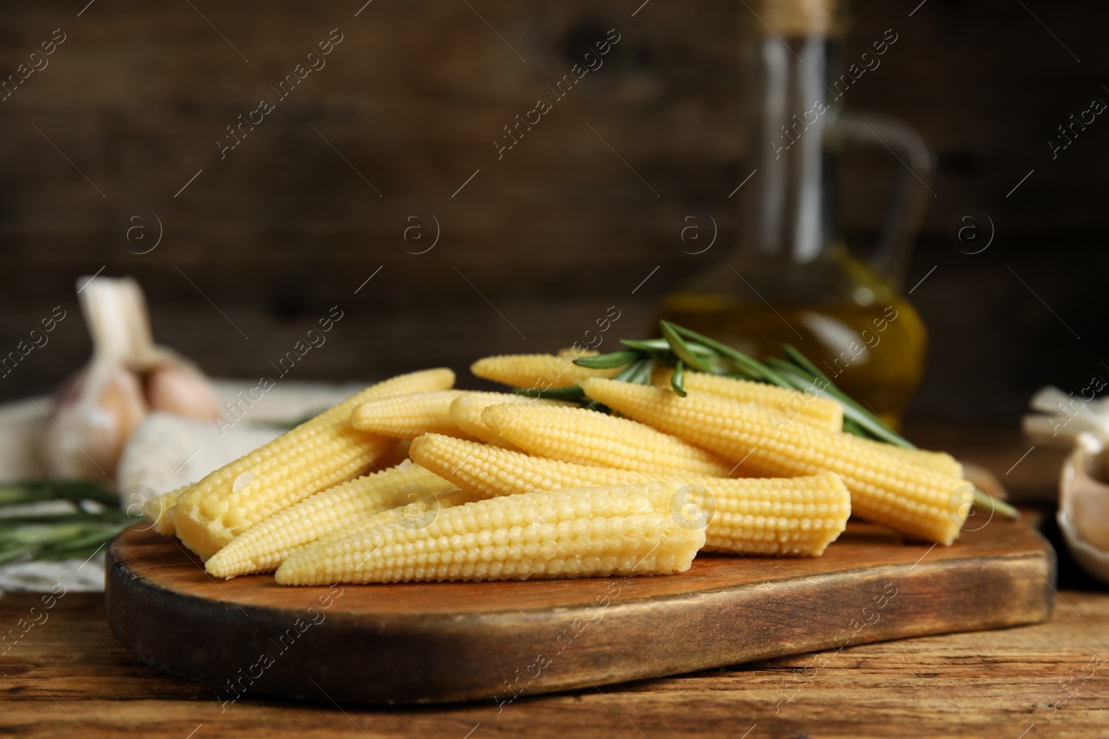 Photo of Fresh baby corn cobs on wooden table