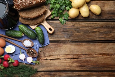 Photo of Flat lay composition with kvass and other okroshka ingredients on wooden table, space for text. Traditional Russian summer soup