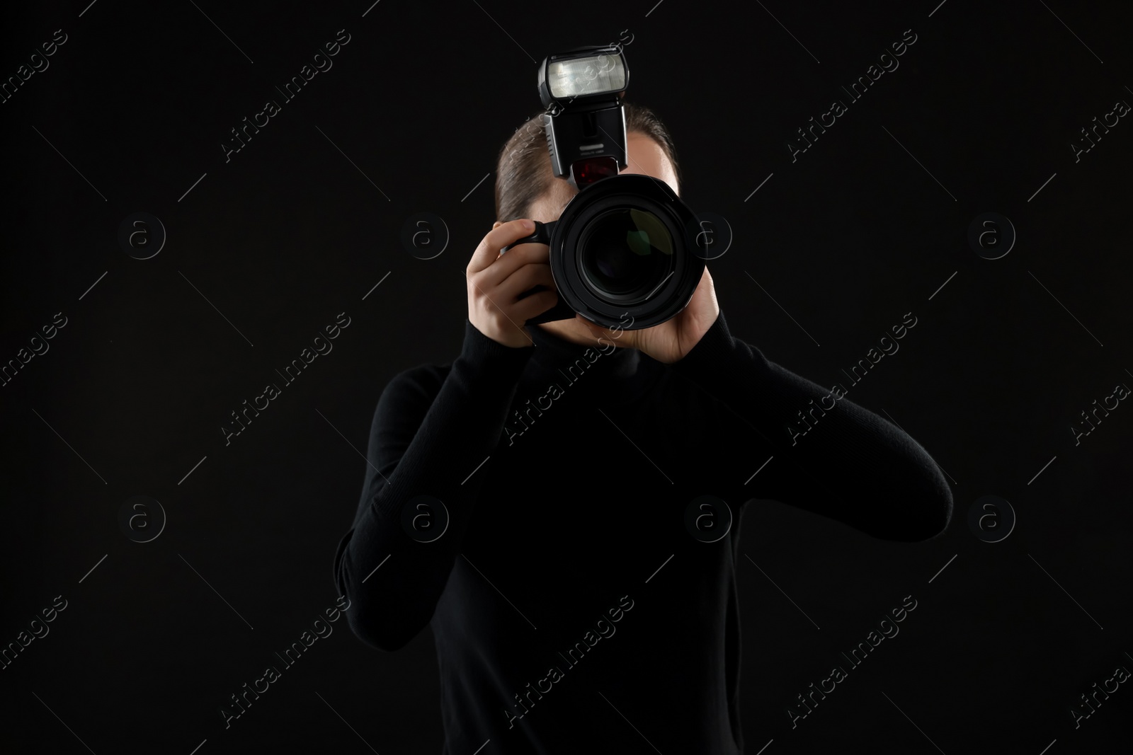 Photo of Professional photographer taking picture on black background